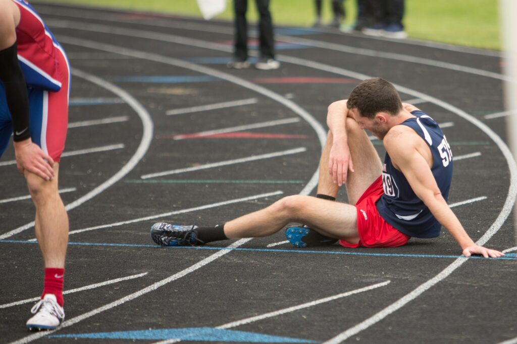 runner sitting on track with performance anxiety